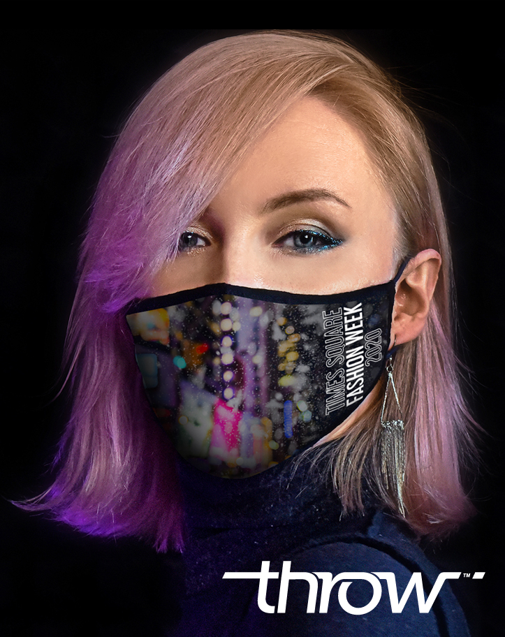 Woman with blonde and purple hair wearing the Times Square Fashion Week 2020 mask. The mask shows a bokeh style picture of Times Square on a black background and the Times Square Fashion Week logo.